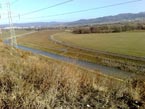 Nové koryto rieky Nitra po prekládke zo starého koryta, v pozadí Prievidza